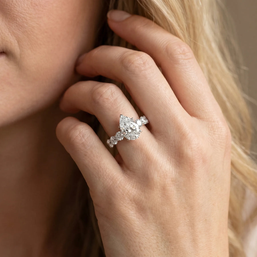 White gold Pear Cut Diamond Prong Setting with Side Stones on a Pave Band
