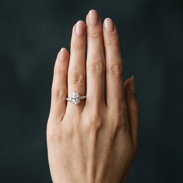 White gold Pear Cut Diamond Ring with Baguette Side Stones, Channel Set Band, and Four-Prong Setting