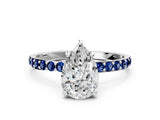 White gold Pear Cut Diamond Solitaire Ring with Round with Blue Sapphire side stone Pavé Band and Prong Setting