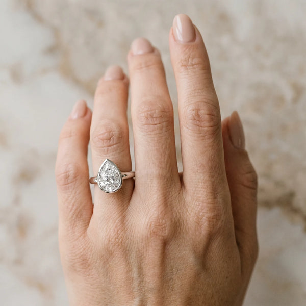 White gold Pear Diamond Solitaire Ring with Bezel Setting and Classic Band