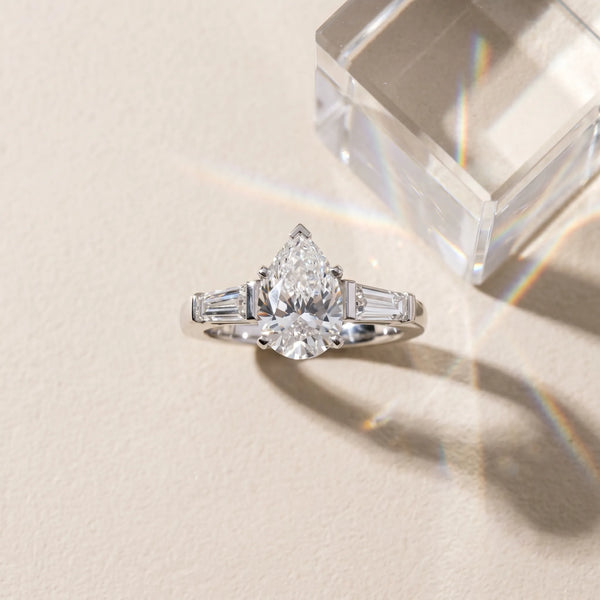 White gold Pear Solitaire with Tapered Baguette Side Stones on a Classic Band with Six-Prong Setting