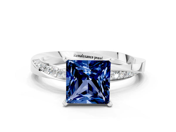 White gold Princess Cut Blue Sapphire Engagement Ring with Side Stone Accents and Four-Prong Setting