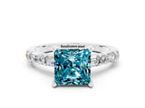 White gold Princess Cut Blue Topaz Solitaire with Side Baguettes and Channel Set Band