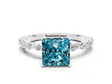 White gold Princess Cut Blue Topaz Solitaire with Side Stones on a Pavé Band and Four-Prong Setting
