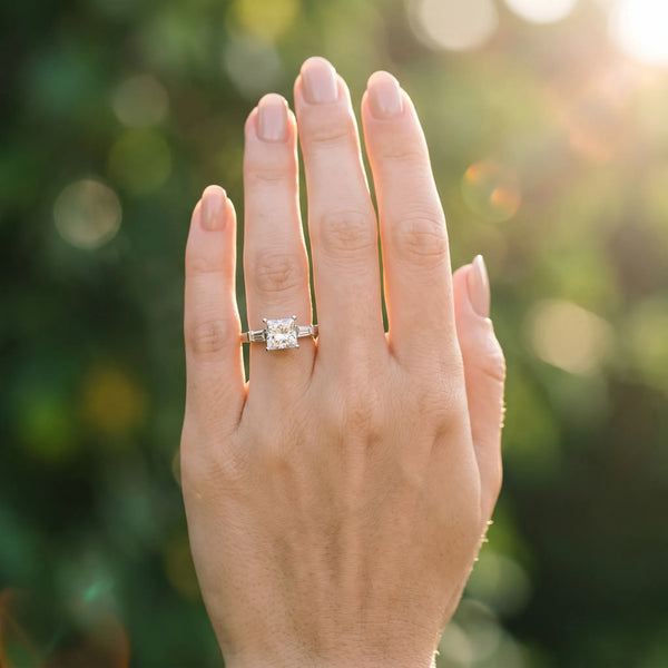 White gold Princess Cut Diamond Solitaire Ring with Tapered Baguette Accents and Four-Prong Setting