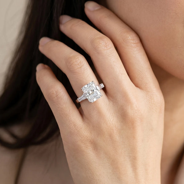 White gold Radiant Cut Diamond Solitaire Ring with Tapered Baguette Accents and Four-Prong Setting