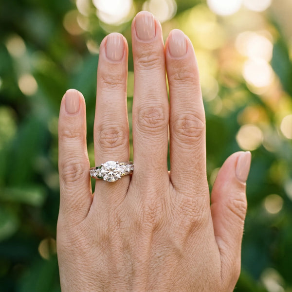 White gold Round Brilliant Solitaire with Side Stones on a Pave Band and Four-Prong Setting