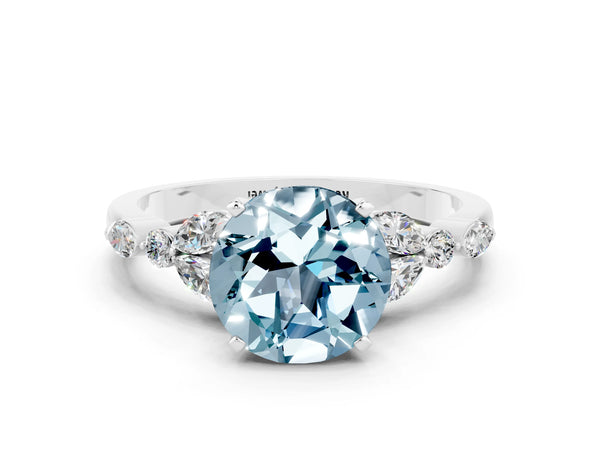 Silver Round Cut Aquamarine Solitaire Ring with Side Stones and Four-Prong Setting