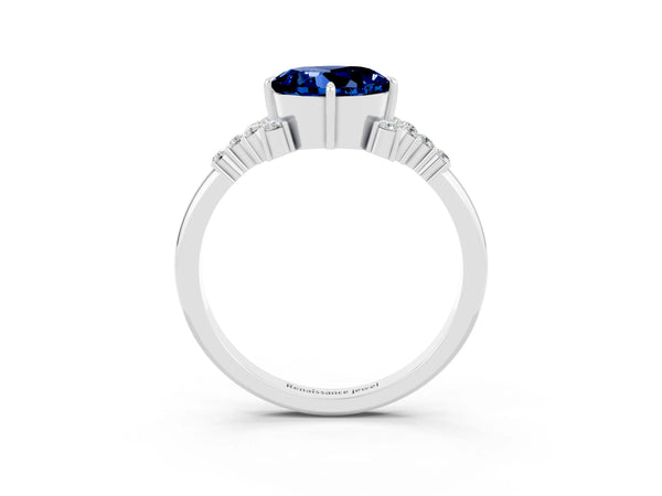 Platinum Round Cut Blue Sapphire Ring with Side Stones and Four-Prong Setting