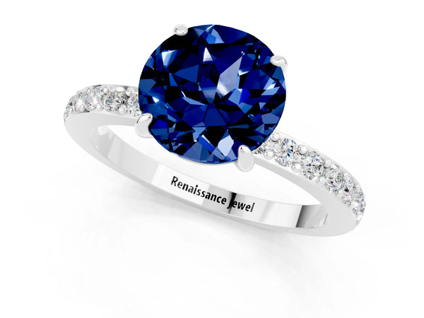 Platinum Round Cut Blue Sapphire Solitaire Engagement Ring with Pavé Band and Four-Prong Setting