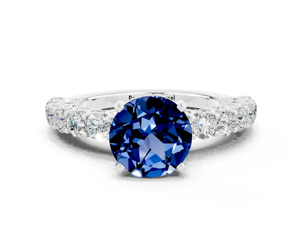 Silver Round Cut Blue Sapphire Solitaire Ring with Shared Prong Pavé Band and Four-Prong Setting