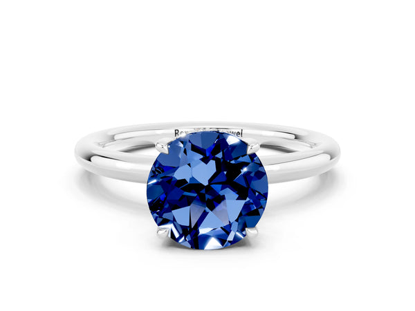 Platinum Round Cut Blue Sapphire Solitaire Ring with Thin Band and Four-Prong Setting