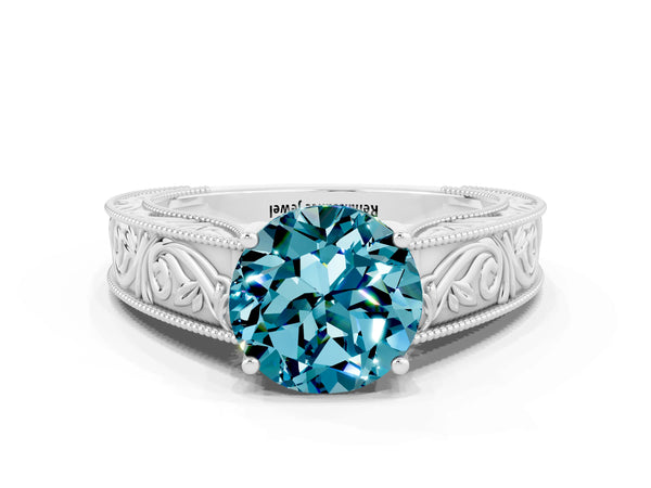 Platinum Round Cut Blue Topaz Solitaire Ring with Engraved Band and Four-Prong Setting