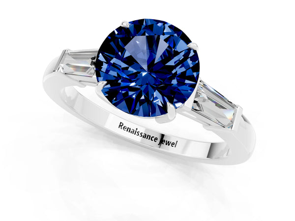 Platinum Round Cut Blue Sapphire Three-Stone Ring with Tapered Baguette Side Stones and Prong Setting