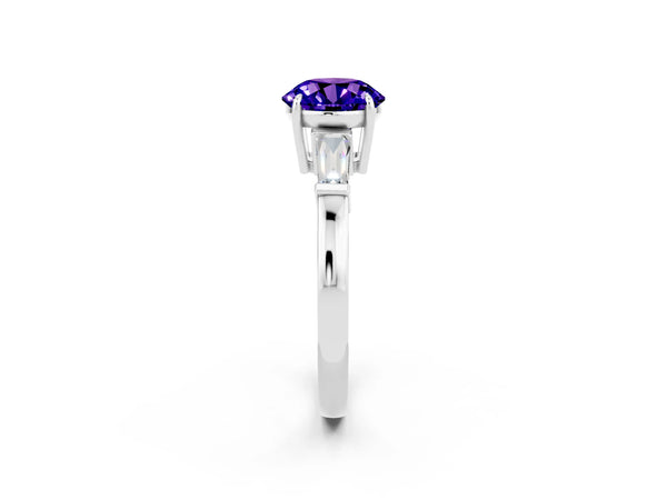 Platinum Round Cut Tanzanite Three-Stone Ring with Tapered Baguette Side Stones and Prong Setting