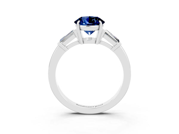 Platinum Round Cut Blue Sapphire Three-Stone Ring with Tapered Baguette Side Stones and Prong Setting