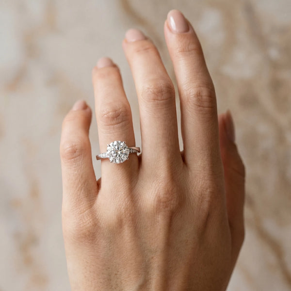White gold Round Cut Diamond Engagement Ring with Side Stone Accents and Four-Prong Setting