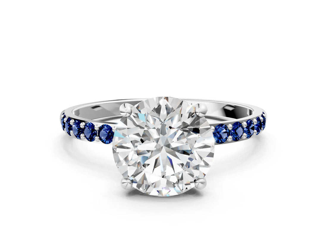 White gold Round Cut Diamond Solitaire Ring with Round with Blue Sapphire side stone Pavé Band and Prong Setting