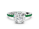 White gold Round Cut Diamond Solitaire Ring with Round with Emerald side stone Pavé Band and Four-Prong Setting