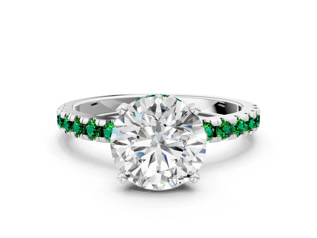 White gold Round Cut Diamond Solitaire Ring with Round with Emerald side stone Pavé Band and Four-Prong Setting