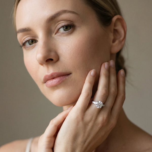 White gold Round Cut Diamond Solitaire Ring with Tapered Baguette Accents and Four-Prong Setting