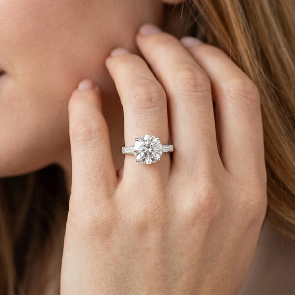 White gold Round Cut Diamond Solitaire Ring with Tapered Baguette Accents and Four-Prong Setting