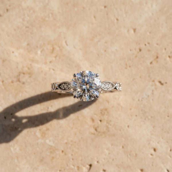 White gold Round Cut Diamond with Milgrain Marquise and Bezel Accents on a Solitaire Band with Prong Setting