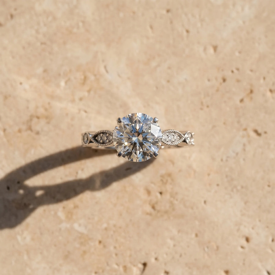White gold Round Cut Diamond with Milgrain Marquise and Bezel Accents on a Solitaire Band with Prong Setting