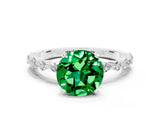White gold Round Cut Emerald Solitaire with Side Stones on a Pavé Band and Four-Prong Setting