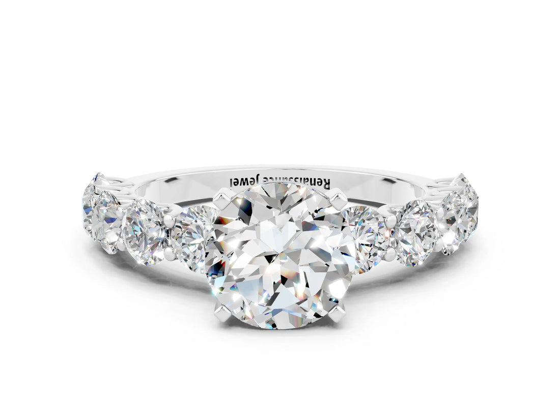 White gold Round Cut Moissanite Prong Setting with Side Stones on a Pave Band