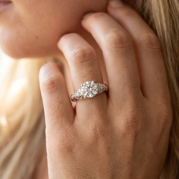 White gold Round Solitaire Scrollwork Engagement Ring with Side Stones and Four-Prong Setting