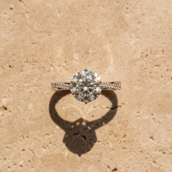 White gold Round Solitaire Twist Band with Pavé Diamonds and Four-Prong Setting