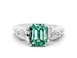 White gold Three-Stone Emerald Cut Cut Diamond Ring with Trillion Side Stones and Four-Prong Setting