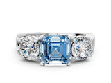 White gold Three-Stone Fancy Blue Asscher Cut Diamond Ring with Round Side Stones, Classic Band, and Four-Prong Setting