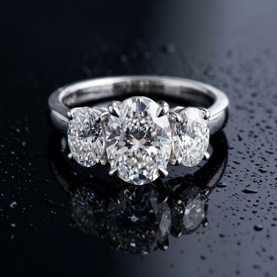 White gold Three-Stone Oval Cut Diamond Ring with Channel Set Band and Four-Prong Setting