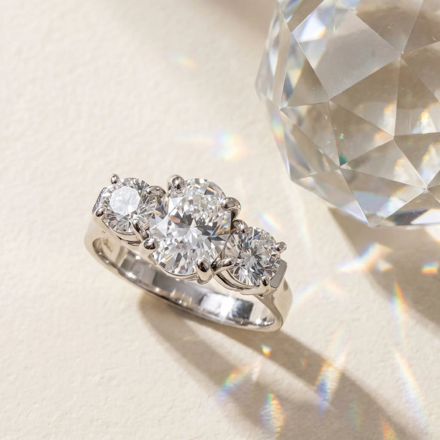 White gold Three-Stone Oval Cut Diamond Ring with Round Accent Stones, Prong Setting, and Classic Band