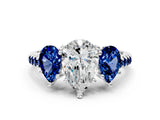 White gold Three-Stone Pear Cut Diamond Ring with Round with Blue Sapphire side stone Pavé Band and Prong Setting