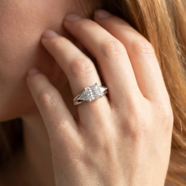 White gold Three-Stone Princess Cut Diamond Ring with Trillion Side Stones on a Split Shank Band