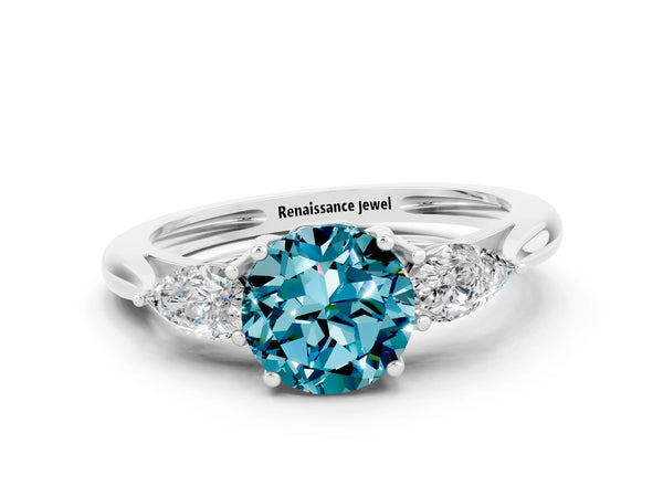 Platinum Three-Stone Round Cut Blue Topaz Ring with Pear  Side Stones in Four-Prong Setting