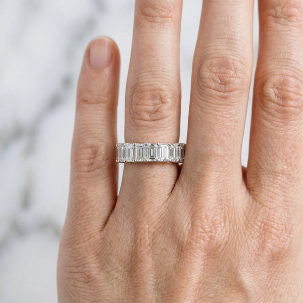 Platinum emerald cut diamond half eternity band with shared prong setting