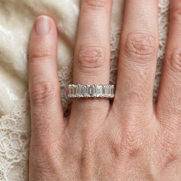 White gold emerald cut diamond half eternity band with shared prong setting