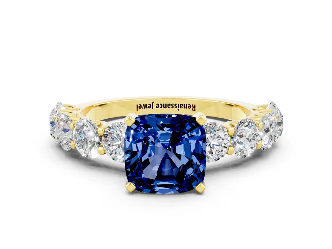 Yellow gold Cushion Cut Blue Sapphire Prong Setting with Side Stones on a Pave Band