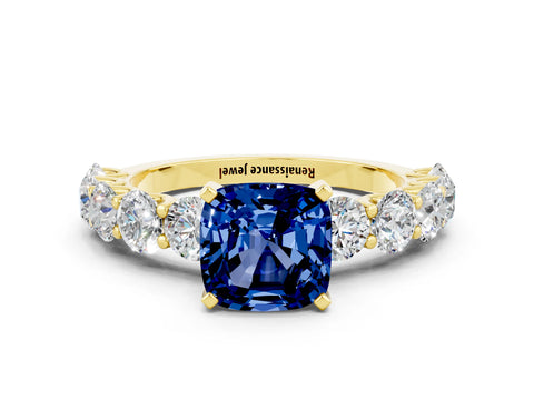 Yellow gold Cushion Cut Blue Sapphire Prong Setting with Side Stones on a Pave Band