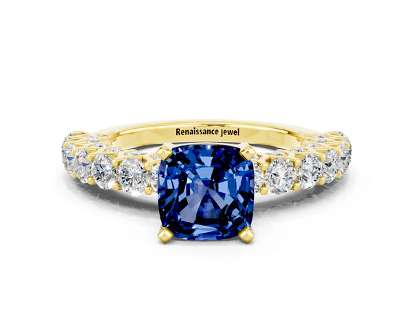 Yellow gold Cushion Cut Blue Sapphire Solitaire Ring with Shared Prong Pavé Band and Four-Prong Setting