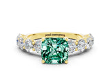 Yellow gold Cushion Cut Green Sapphire Prong Setting with Side Stones on a Pave Band
