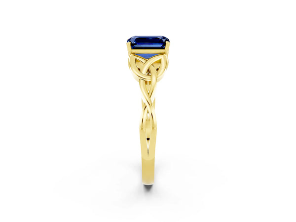 Yellow gold Emerald Cut Blue Sapphire Solitaire Engagement Ring with Celtic Knot Band and Four-Prong Setting