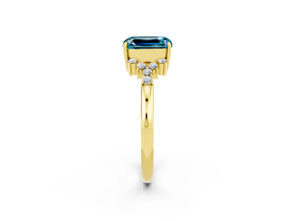 Yellow gold Emerald Cut Blue Topaz Ring with Side Stones and Four-Prong Setting