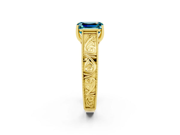Yellow gold Emerald Cut Blue Topaz Solitaire Ring with Engraved Band and Four-Prong Setting