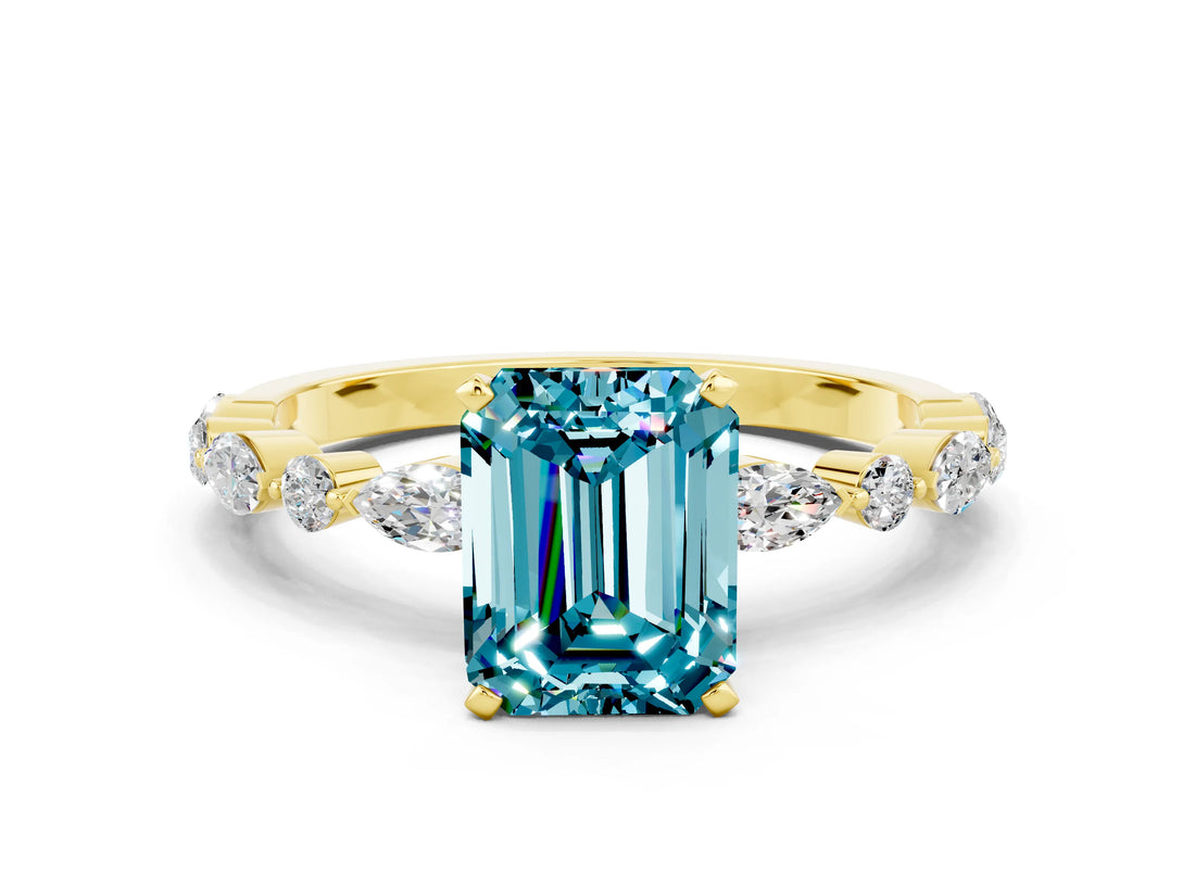 Yellow gold Emerald Cut Blue Topaz Solitaire with Side Stones on a Pavé Band and Four-Prong Setting