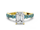 Yellow gold Emerald Cut Diamond Side Stone Solitaire Ring with Round with Blue Topaz side stone and Four-Prong Setting